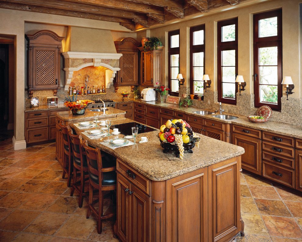 Inspiration for a mediterranean kitchen in Miami with dark wood cabinets, integrated appliances and an island.