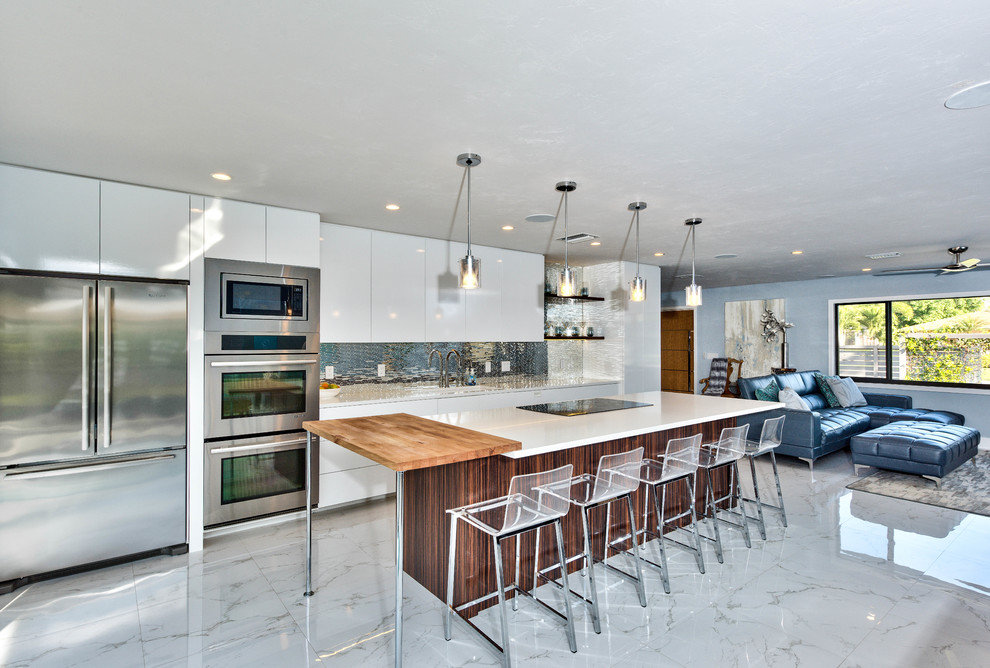 Idéer för mellanstora funkis linjära vitt kök med öppen planlösning, med en undermonterad diskho, släta luckor, vita skåp, bänkskiva i koppar, stänkskydd med metallisk yta, stänkskydd i metallkakel, rostfria vitvaror, marmorgolv, en köksö och grått golv