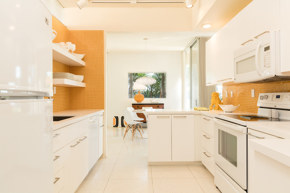 Источник вдохновения для домашнего уюта: параллельная кухня в стиле ретро с обеденным столом, врезной мойкой, плоскими фасадами, желтым фартуком, фартуком из плитки мозаики и белой техникой