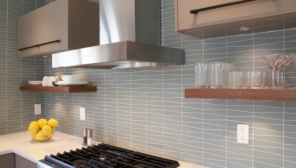 Foto di una cucina moderna di medie dimensioni con lavello sottopiano, ante lisce, ante grigie, top in quarzo composito, paraspruzzi blu, paraspruzzi con piastrelle di vetro e elettrodomestici in acciaio inossidabile