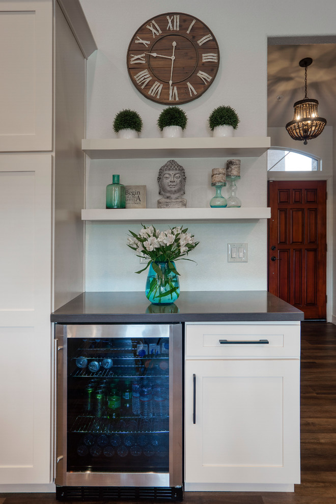 Inspiration for a mid-sized modern l-shaped medium tone wood floor and brown floor open concept kitchen remodel with an undermount sink, shaker cabinets, white cabinets, white backsplash, mosaic tile backsplash, stainless steel appliances, an island and gray countertops