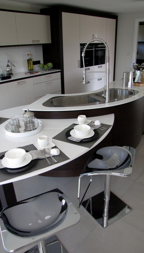 Immagine di un'ampia cucina minimalista con ante lisce, ante in legno scuro, top in quarzite e elettrodomestici in acciaio inossidabile