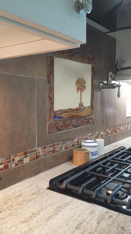 Inredning av ett modernt kök, med skåp i shakerstil, granitbänkskiva, flerfärgad stänkskydd, stänkskydd i keramik och en köksö