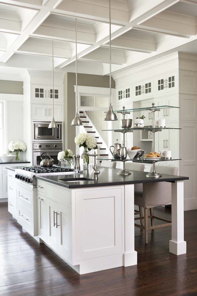 Open concept kitchen - large traditional u-shaped dark wood floor open concept kitchen idea in Charleston with stainless steel appliances, shaker cabinets, an island, granite countertops, an undermount sink and black countertops