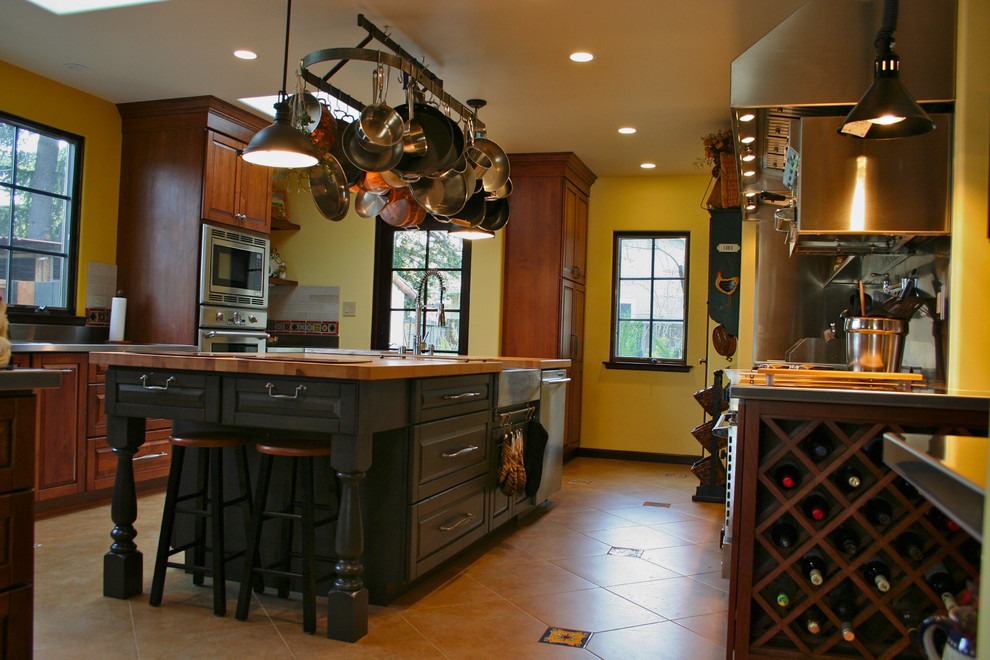 Enclosed kitchen - large mediterranean u-shaped ceramic tile enclosed kitchen idea in San Francisco with a farmhouse sink, raised-panel cabinets, dark wood cabinets, stainless steel countertops, stainless steel appliances, multicolored backsplash, ceramic backsplash and an island