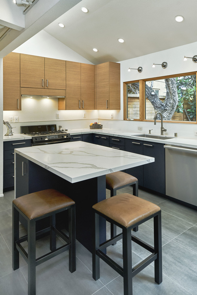 Exempel på ett avskilt, mellanstort modernt vit vitt u-kök, med en undermonterad diskho, släta luckor, skåp i ljust trä, marmorbänkskiva, vitt stänkskydd, glaspanel som stänkskydd, rostfria vitvaror, skiffergolv, en köksö och grått golv