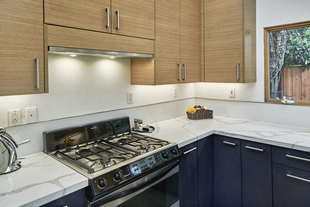 Medium sized contemporary u-shaped enclosed kitchen in San Francisco with a submerged sink, flat-panel cabinets, light wood cabinets, marble worktops, white splashback, glass sheet splashback, stainless steel appliances, slate flooring, an island, grey floors and white worktops.