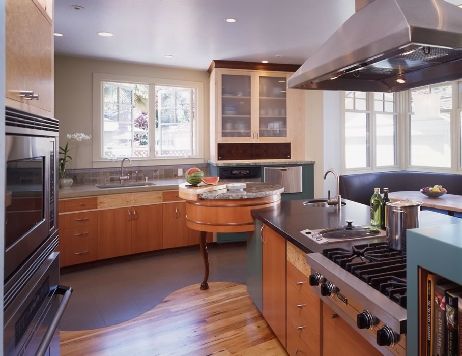 Immagine di una cucina minimal di medie dimensioni con lavello sottopiano, ante in legno scuro, paraspruzzi beige, paraspruzzi con piastrelle di vetro, elettrodomestici in acciaio inossidabile e pavimento in legno massello medio