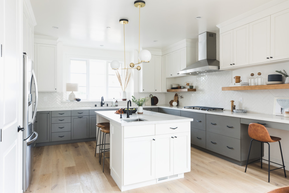 Large classic u-shaped open plan kitchen in San Francisco with a submerged sink, shaker cabinets, grey cabinets, engineered stone countertops, white splashback, ceramic splashback, stainless steel appliances, medium hardwood flooring, an island, brown floors and yellow worktops.