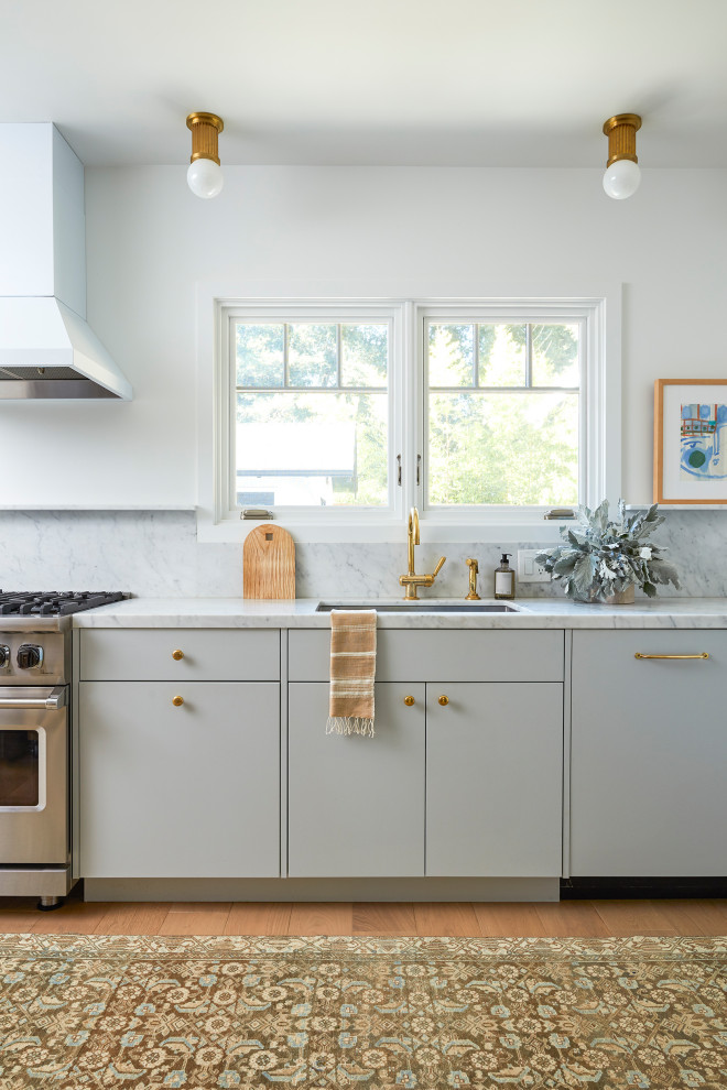 Foto på ett mellanstort funkis grå kök och matrum, med en nedsänkt diskho, släta luckor, marmorbänkskiva, grått stänkskydd, stänkskydd i marmor, rostfria vitvaror, mellanmörkt trägolv, en köksö, brunt golv och blå skåp