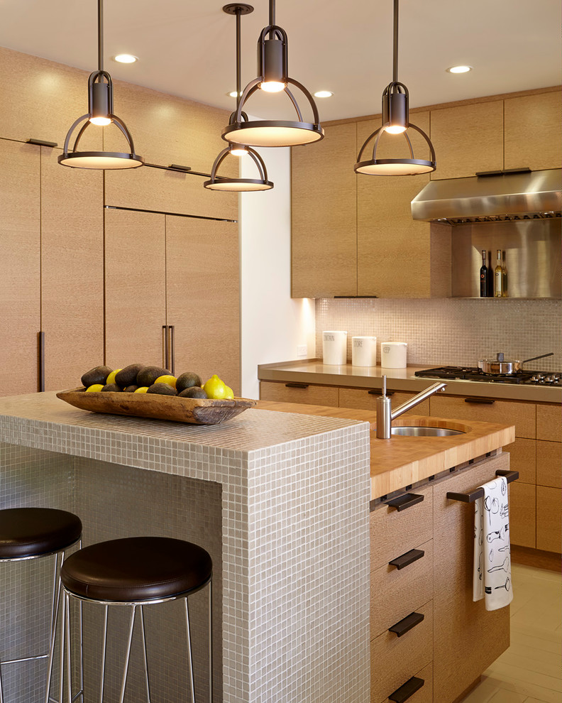 Esempio di una cucina minimal di medie dimensioni con lavello sottopiano, ante lisce, top in legno, paraspruzzi beige, paraspruzzi con piastrelle di vetro, elettrodomestici in acciaio inossidabile, parquet chiaro e pavimento beige
