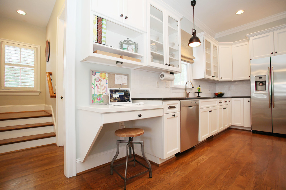 Foto de cocina clásica abierta con armarios estilo shaker, puertas de armario blancas, salpicadero blanco, electrodomésticos de acero inoxidable y suelo de madera en tonos medios