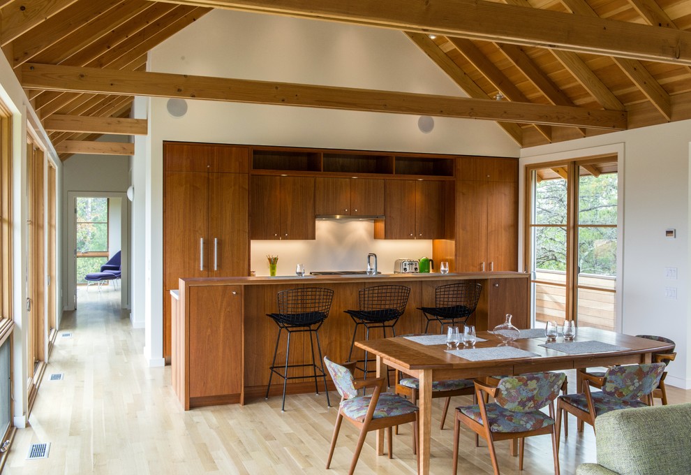 Idée de décoration pour une cuisine ouverte linéaire et encastrable chalet en bois foncé de taille moyenne avec parquet clair, un placard à porte plane, îlot et un sol beige.