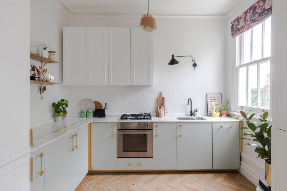 Inspiration for a classic l-shaped kitchen in London with a submerged sink, flat-panel cabinets, grey cabinets, medium hardwood flooring, no island, brown floors and white worktops.