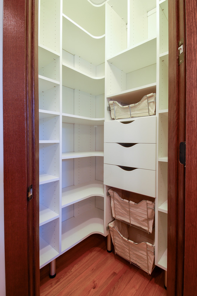 Foto de cocinas en L actual pequeña cerrada con armarios con paneles lisos, puertas de armario blancas y suelo de madera en tonos medios