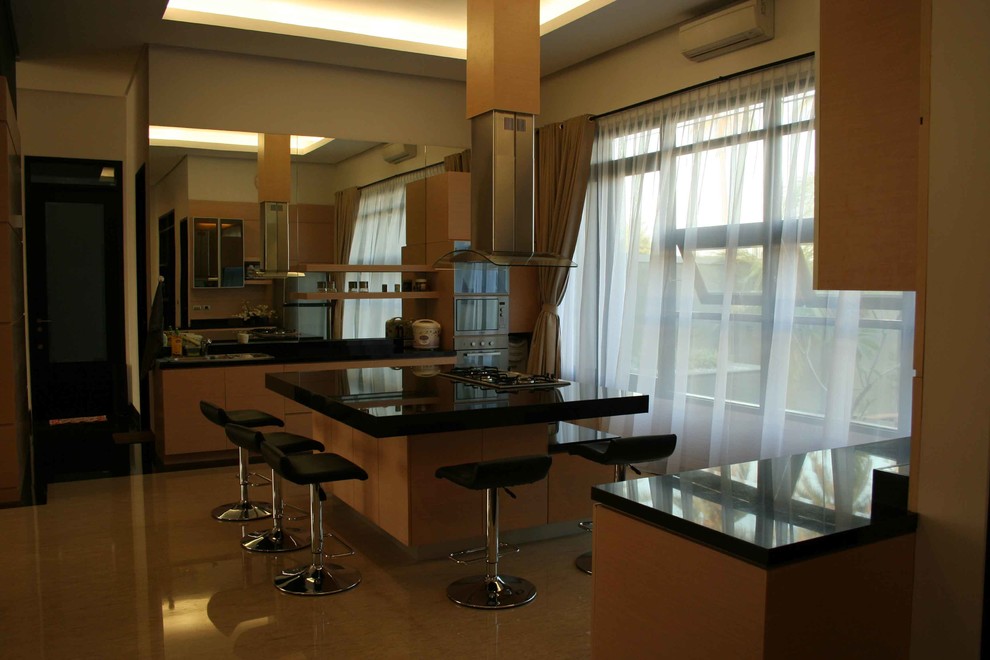 Foto di una grande cucina minimalista con lavello sottopiano, ante lisce, ante in legno chiaro, top in granito, paraspruzzi a specchio, pavimento in marmo, pavimento beige e top nero
