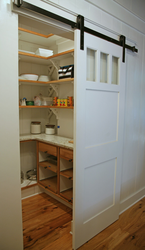 Immagine di una piccola cucina a L industriale con nessun'anta, ante bianche, top in granito, paraspruzzi bianco e parquet chiaro