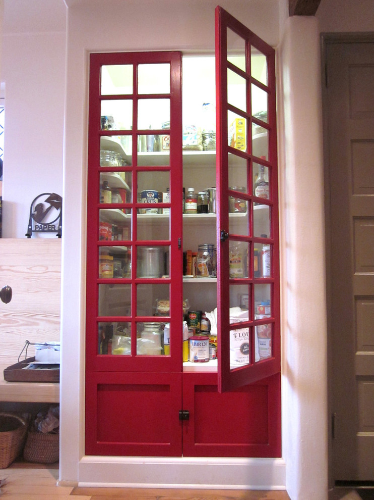 Modelo de cocina moderna con armarios estilo shaker, puertas de armario rojas y despensa
