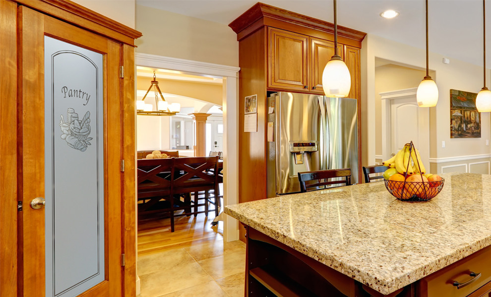 Example of a mid-sized arts and crafts l-shaped kitchen pantry design in Other with raised-panel cabinets, medium tone wood cabinets, granite countertops, beige backsplash, ceramic backsplash, stainless steel appliances and an island