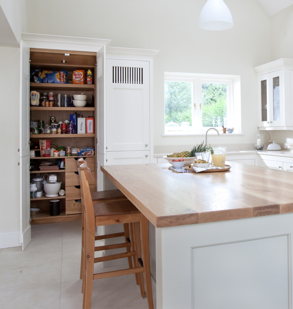 Medium sized classic kitchen in Other with glass-front cabinets, white cabinets, an island and beige floors.