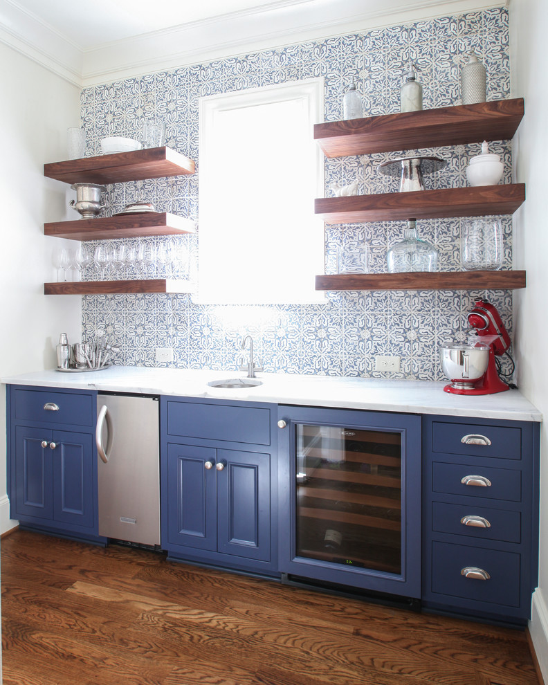 This is an example of a small traditional single-wall kitchen in Charlotte with a submerged sink, recessed-panel cabinets, blue cabinets, marble worktops, blue splashback, porcelain splashback, stainless steel appliances and medium hardwood flooring.
