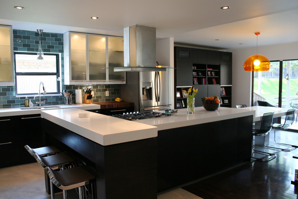 Kitchen - contemporary galley kitchen idea in Dallas with glass-front cabinets, quartz countertops, blue backsplash, subway tile backsplash and stainless steel appliances