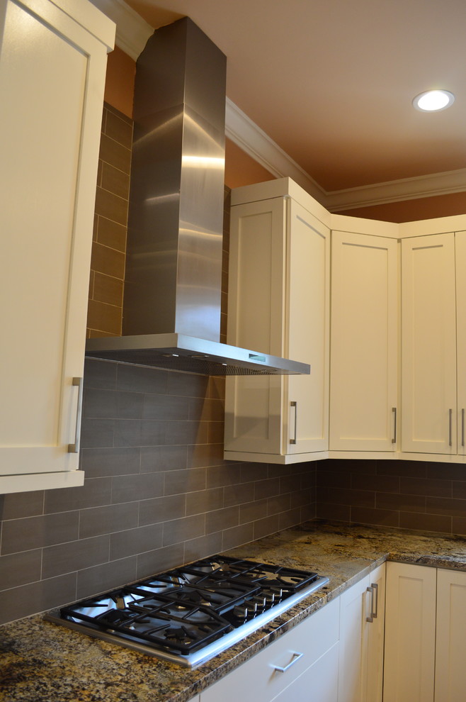 Example of a trendy eat-in kitchen design in Atlanta with a drop-in sink, flat-panel cabinets, white cabinets, granite countertops, gray backsplash, stone tile backsplash and stainless steel appliances