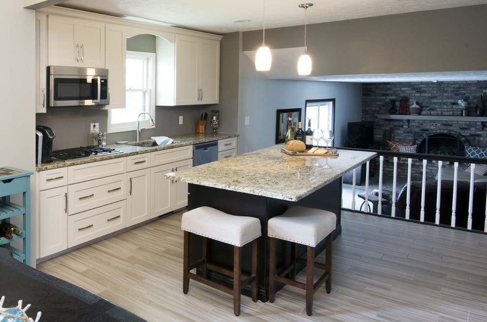 Small transitional galley light wood floor kitchen photo in Omaha with an undermount sink, flat-panel cabinets, white cabinets, granite countertops, gray backsplash, stainless steel appliances and an island
