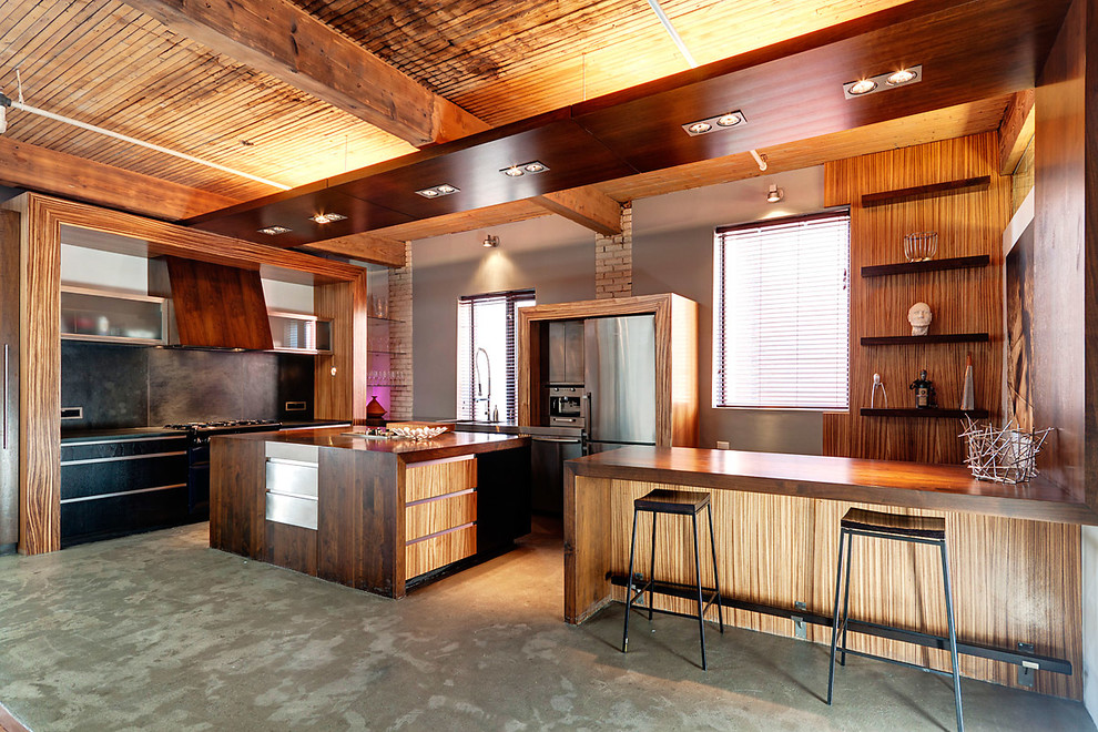 モントリオールにあるコンテンポラリースタイルのおしゃれなキッチン (フラットパネル扉のキャビネット、木材カウンター、シルバーの調理設備) の写真