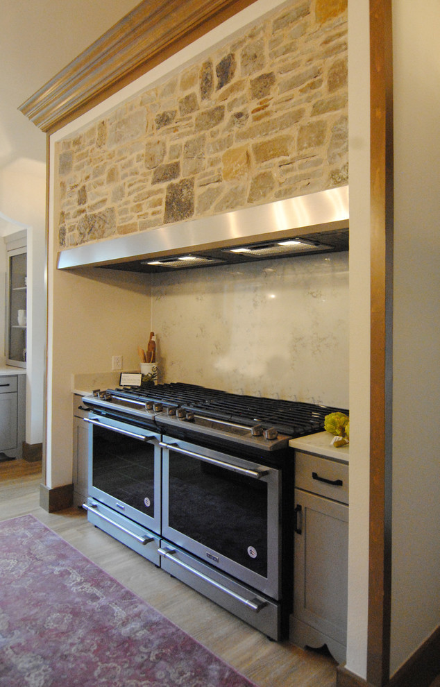 Inredning av ett eklektiskt stort kök, med en rustik diskho, luckor med upphöjd panel, grå skåp, bänkskiva i kvarts, vitt stänkskydd, stänkskydd i sten, rostfria vitvaror, vinylgolv, flera köksöar och brunt golv