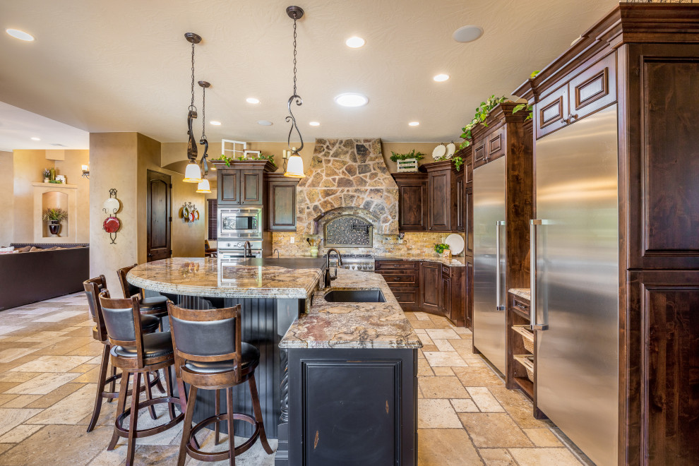 Tuscan l-shaped beige floor kitchen photo in Salt Lake City with an undermount sink, raised-panel cabinets, dark wood cabinets, beige backsplash, stainless steel appliances, an island and brown countertops