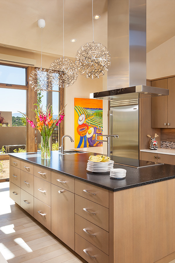 Large southwest single-wall light wood floor eat-in kitchen photo in Albuquerque with an undermount sink, flat-panel cabinets, light wood cabinets, granite countertops, multicolored backsplash, mosaic tile backsplash, stainless steel appliances and an island