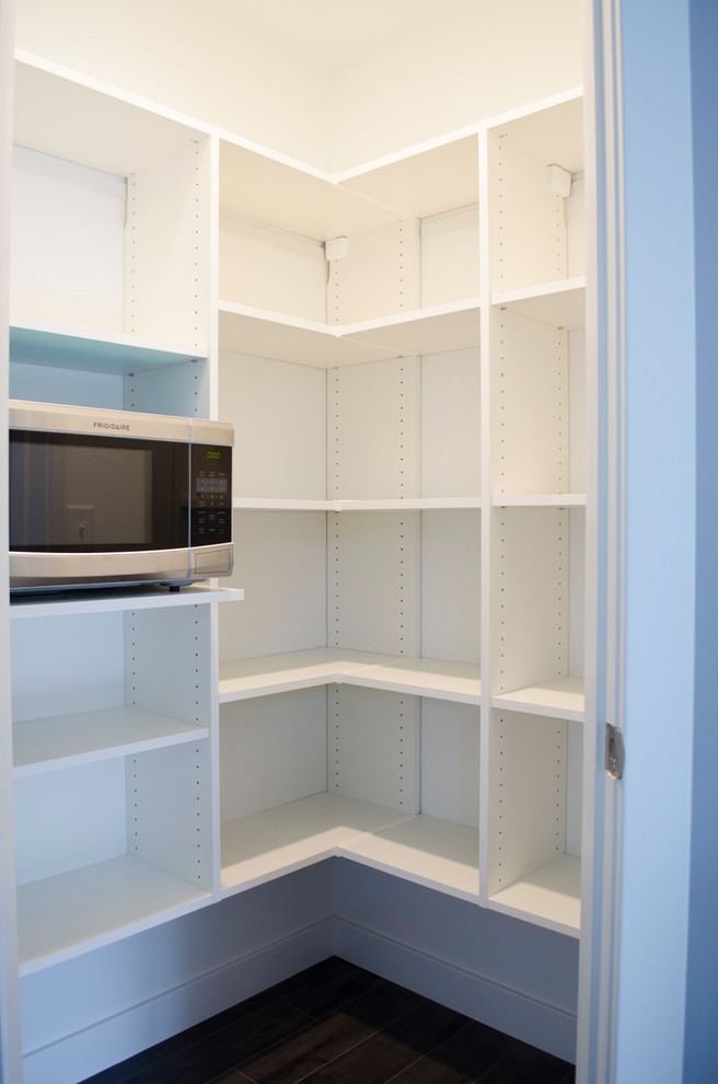 Modelo de cocina minimalista grande con despensa, armarios abiertos, puertas de armario blancas, electrodomésticos de acero inoxidable, moqueta y suelo marrón
