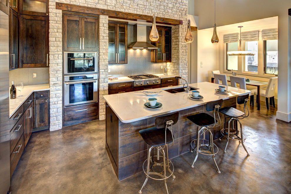 Large elegant l-shaped concrete floor eat-in kitchen photo in Austin with an undermount sink, recessed-panel cabinets, dark wood cabinets, gray backsplash, stainless steel appliances, quartz countertops, ceramic backsplash and an island