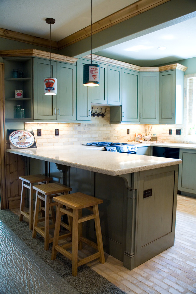 Foto på ett mellanstort industriellt kök, med en undermonterad diskho, luckor med infälld panel, gröna skåp, bänkskiva i kvarts, beige stänkskydd, svarta vitvaror, tegelgolv och en halv köksö
