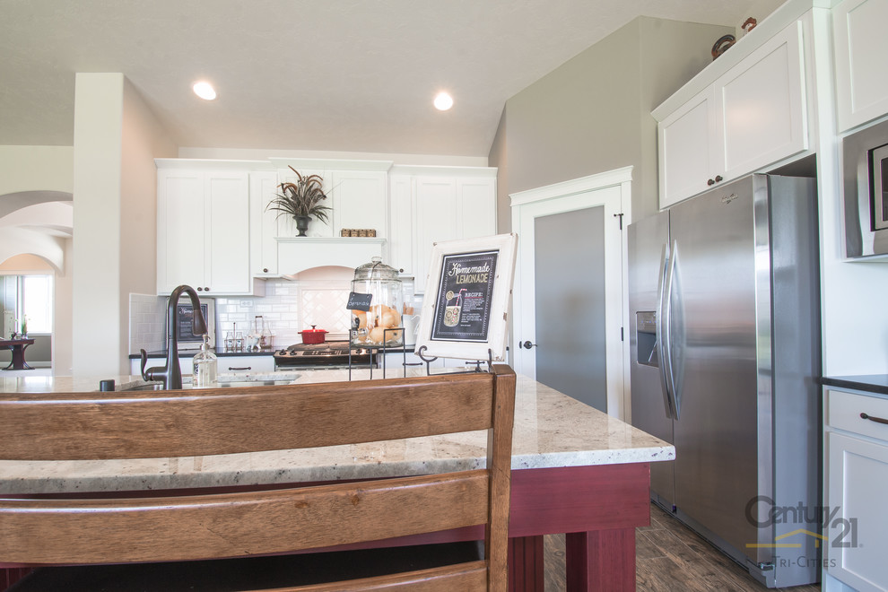 シアトルにあるラスティックスタイルのおしゃれなキッチン (アンダーカウンターシンク、シェーカースタイル扉のキャビネット、白いキャビネット、御影石カウンター、白いキッチンパネル、サブウェイタイルのキッチンパネル、シルバーの調理設備、リノリウムの床) の写真