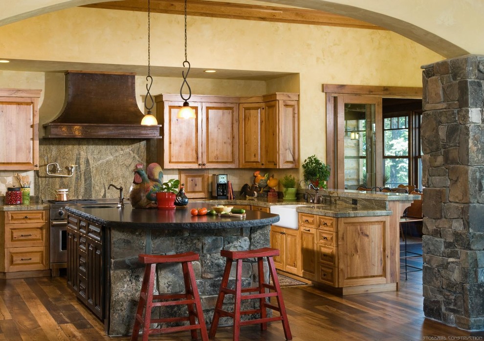Bild på ett mellanstort lantligt kök, med en rustik diskho, luckor med upphöjd panel, skåp i mellenmörkt trä, rostfria vitvaror, mellanmörkt trägolv och en köksö