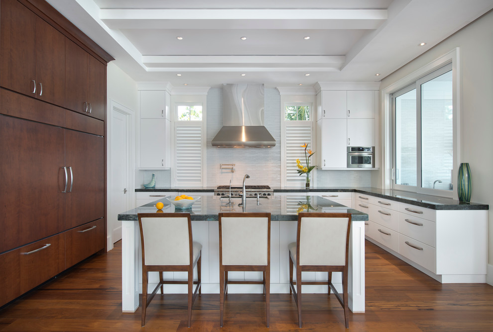 Kitchen - coastal kitchen idea in Miami with flat-panel cabinets, white cabinets, white backsplash, matchstick tile backsplash and paneled appliances