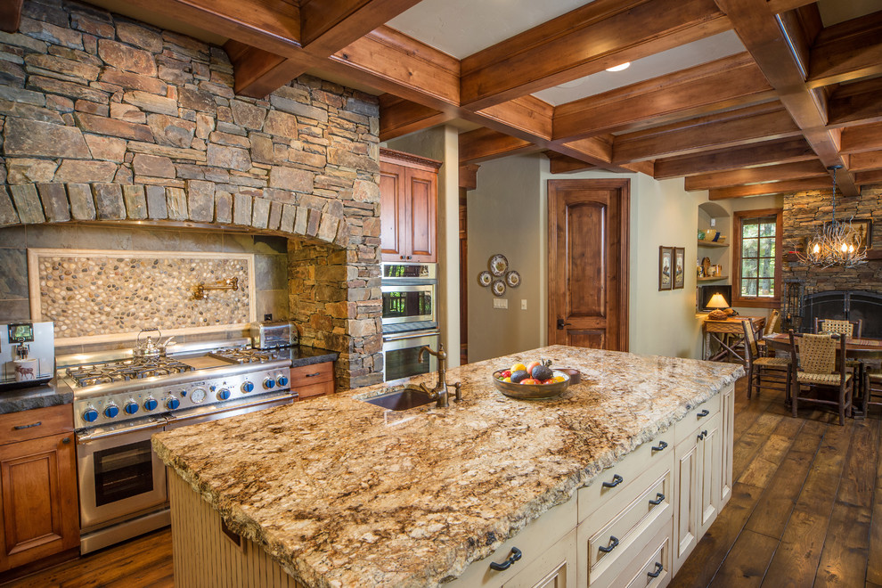 Diseño de cocina comedor rústica con salpicadero de azulejos de piedra, suelo de madera en tonos medios y una isla
