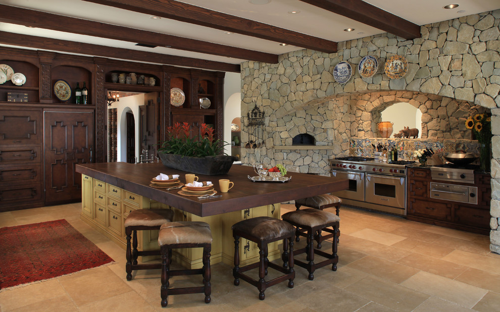Inspiration for a mediterranean kitchen remodel in Phoenix with dark wood cabinets, wood countertops, multicolored backsplash and paneled appliances