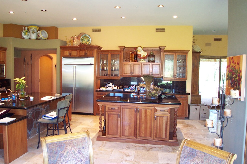 Große Klassische Wohnküche in L-Form mit profilierten Schrankfronten, hellbraunen Holzschränken, Küchenrückwand in Schwarz, Küchengeräten aus Edelstahl und zwei Kücheninseln in Phoenix