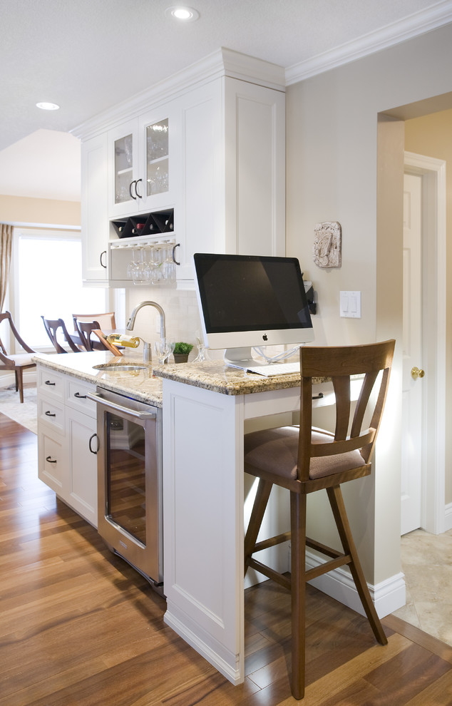 Elegant kitchen photo in Toronto with glass-front cabinets and granite countertops