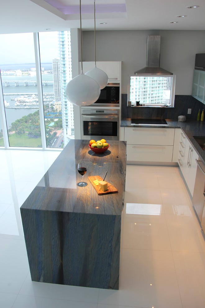 Exempel på ett modernt kök, med en undermonterad diskho, vita skåp, granitbänkskiva och blått stänkskydd