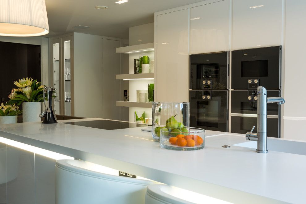 Immagine di una grande cucina minimalista con lavello da incasso, ante lisce, ante bianche, top in superficie solida, elettrodomestici colorati, pavimento in gres porcellanato, pavimento grigio e top bianco