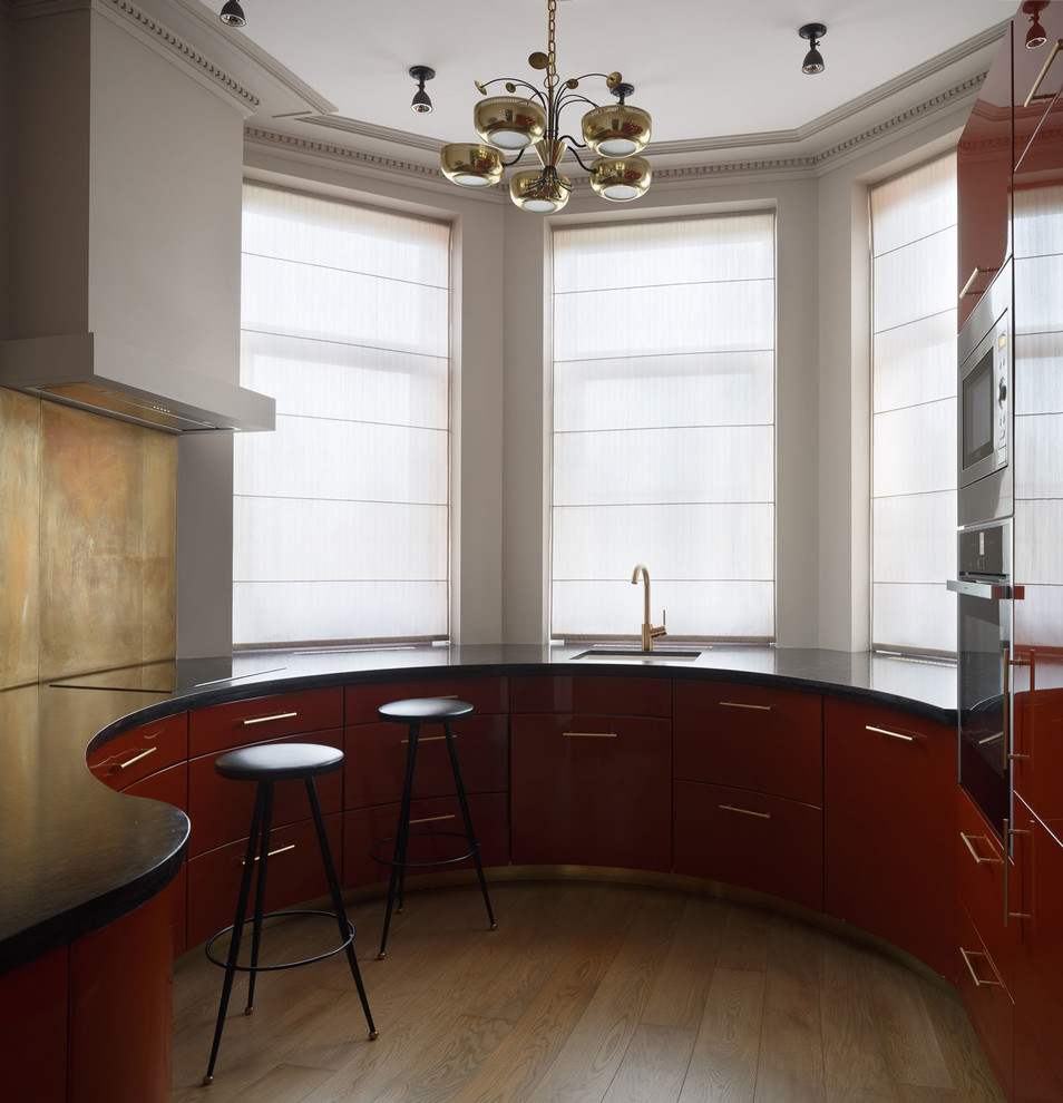 На фото: отдельная кухня в стиле модернизм с врезной мойкой, плоскими фасадами, красными фасадами, бежевым фартуком, коричневым полом и эркером с