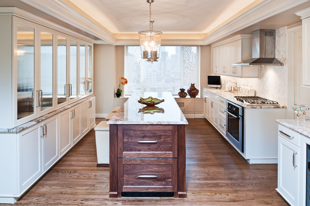 Inspiration for a large contemporary galley light wood floor eat-in kitchen remodel in New York with an undermount sink, recessed-panel cabinets, white cabinets, white backsplash, matchstick tile backsplash, stainless steel appliances and an island