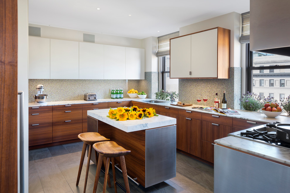 This is an example of a large modern u-shaped kitchen in New York with flat-panel cabinets, white cabinets, marble worktops and an island.