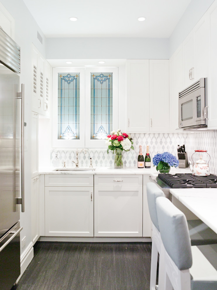 Inspiration for a small victorian galley enclosed kitchen in New York with a submerged sink, shaker cabinets, white cabinets, metallic splashback, stainless steel appliances and dark hardwood flooring.