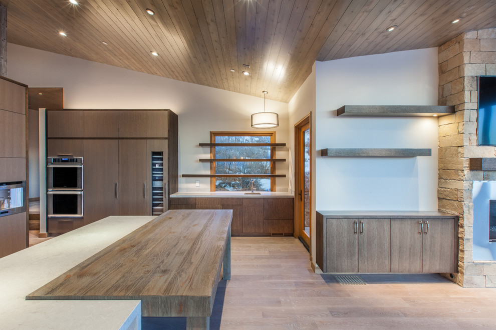 Design ideas for a contemporary open plan kitchen in Salt Lake City with flat-panel cabinets, dark wood cabinets and an island.