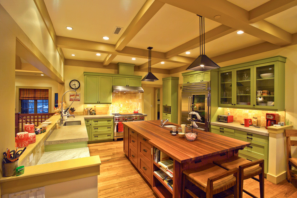 Bild på ett stort amerikanskt kök, med luckor med infälld panel, gröna skåp, en köksö, marmorbänkskiva, brunt stänkskydd, en undermonterad diskho, stänkskydd i stenkakel, rostfria vitvaror och mörkt trägolv